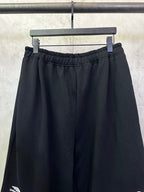 Black wide-leg pants with elastic waistband and front pleats