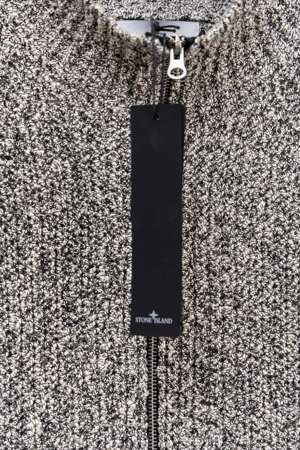 Stone Island speckled knit jacket with black Stone Island label tag, close-up