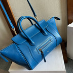 Blue leather top-handle bag with long crossbody strap and front zipper pocket