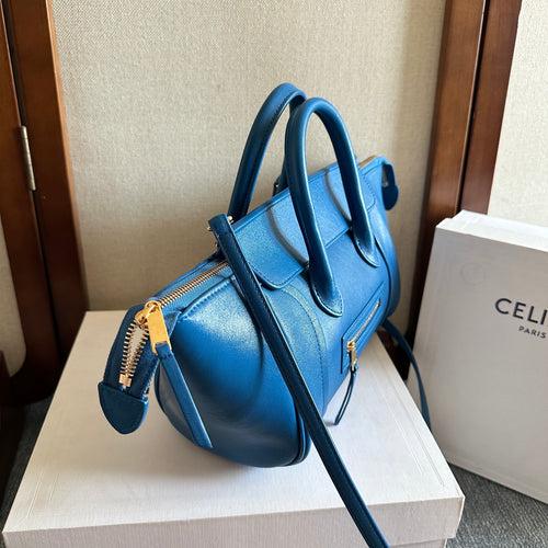 Blue leather top-handle bag with long strap, gold hardware, and front zipper pocket