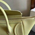 Light yellow Celine bag close-up of top seam, strap loop, and zipper