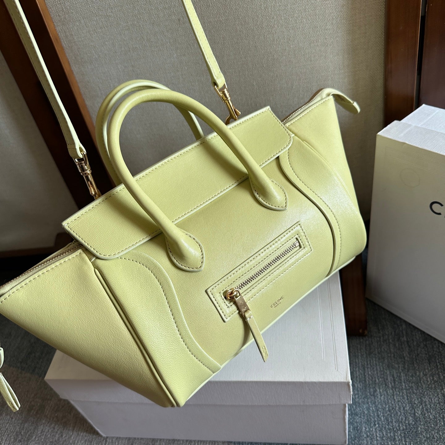 Light yellow Celine tote bag with front zipper, structured panels, and top handles