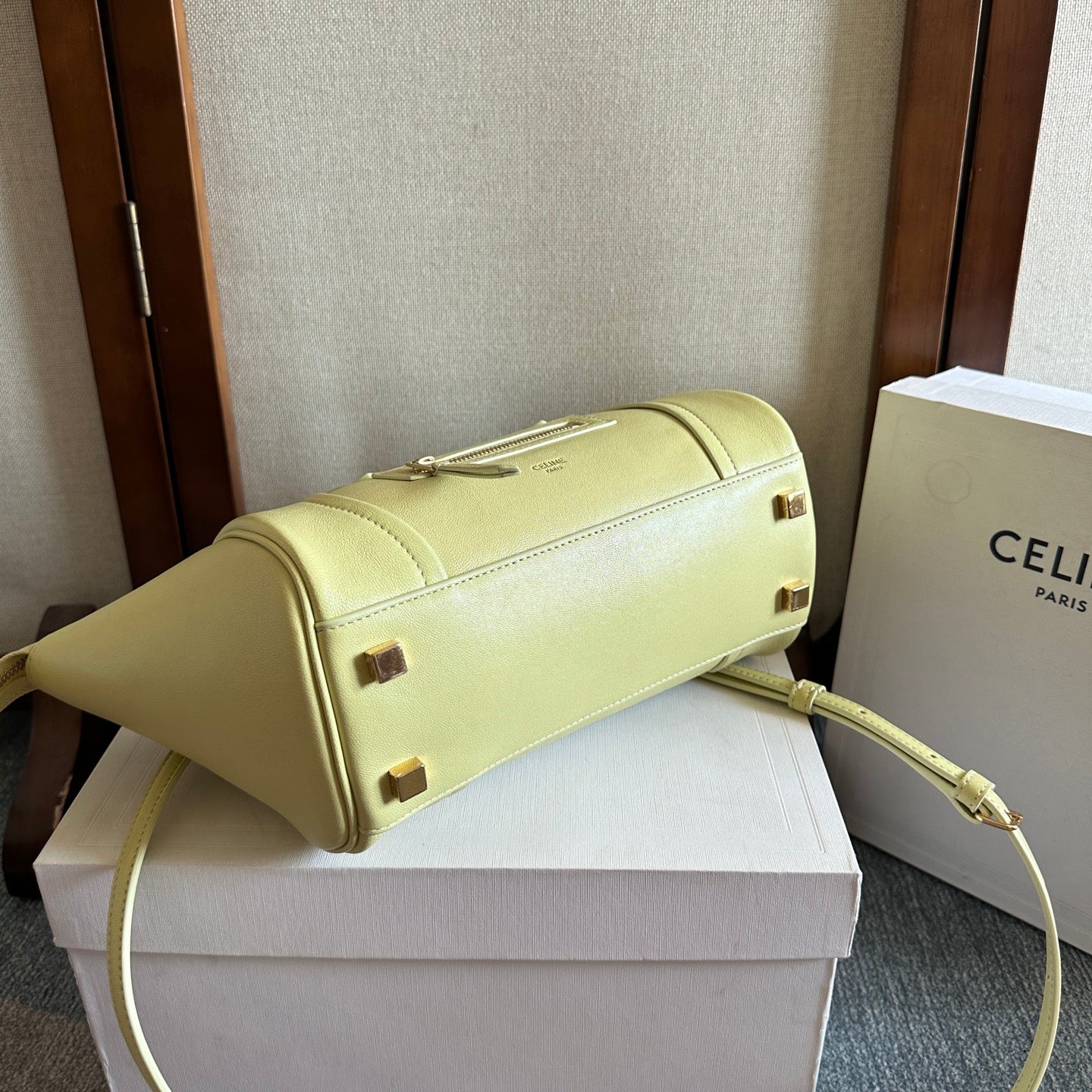 Light yellow Celine top-handle bag with gold-tone hardware and zip closure