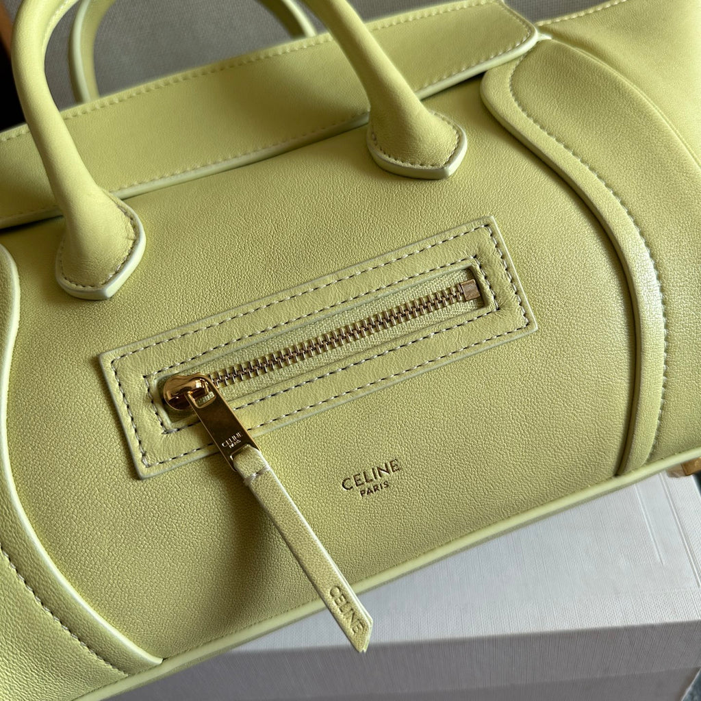 Light yellow Celine bag close-up of front zipper pocket and stitched logo