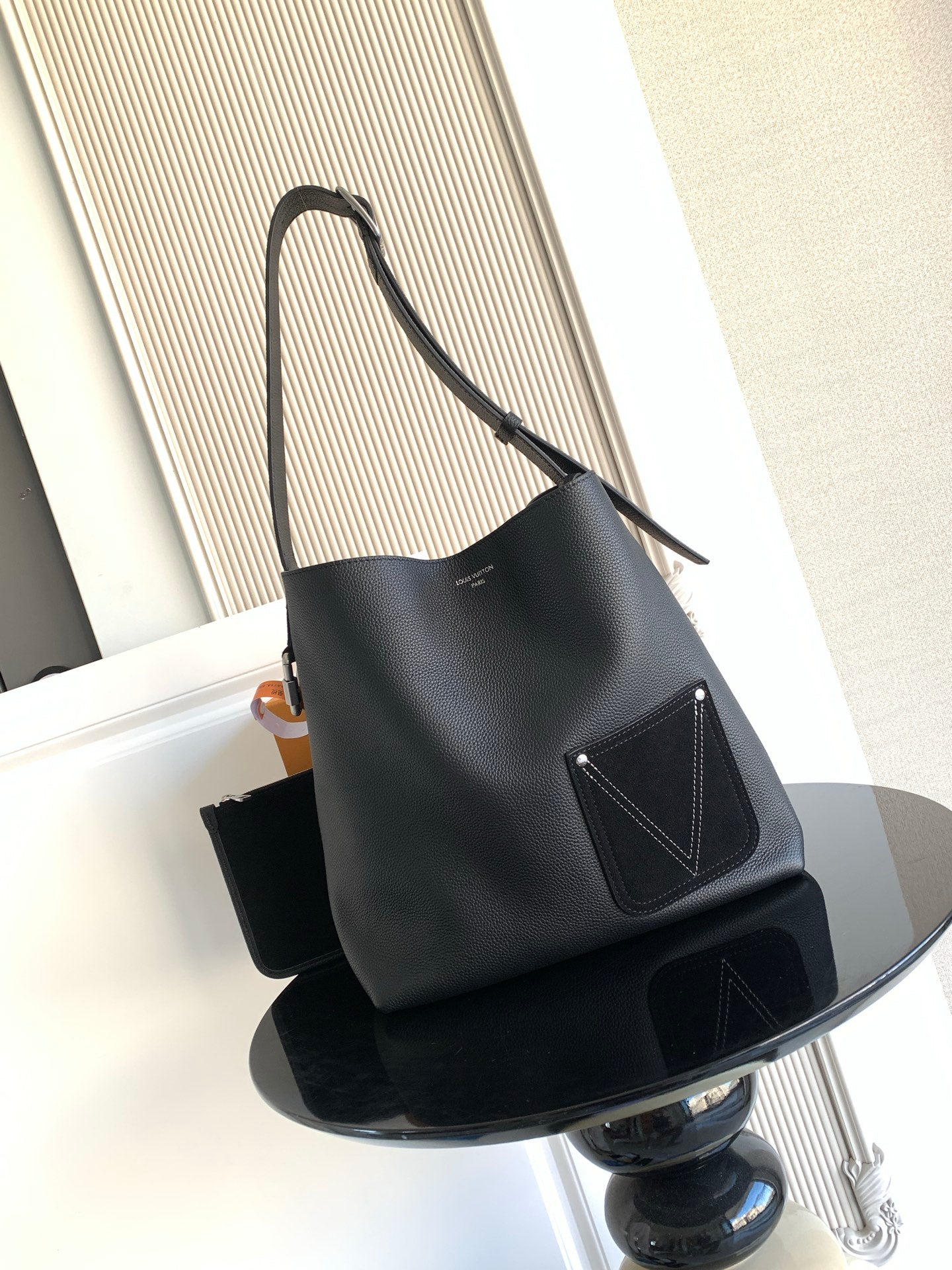 Black shoulder bag with long strap and front flap pocket