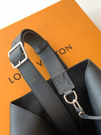 Black leather bag with adjustable strap and metal rings