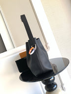 Black leather shoulder bag with adjustable strap and metal clasp