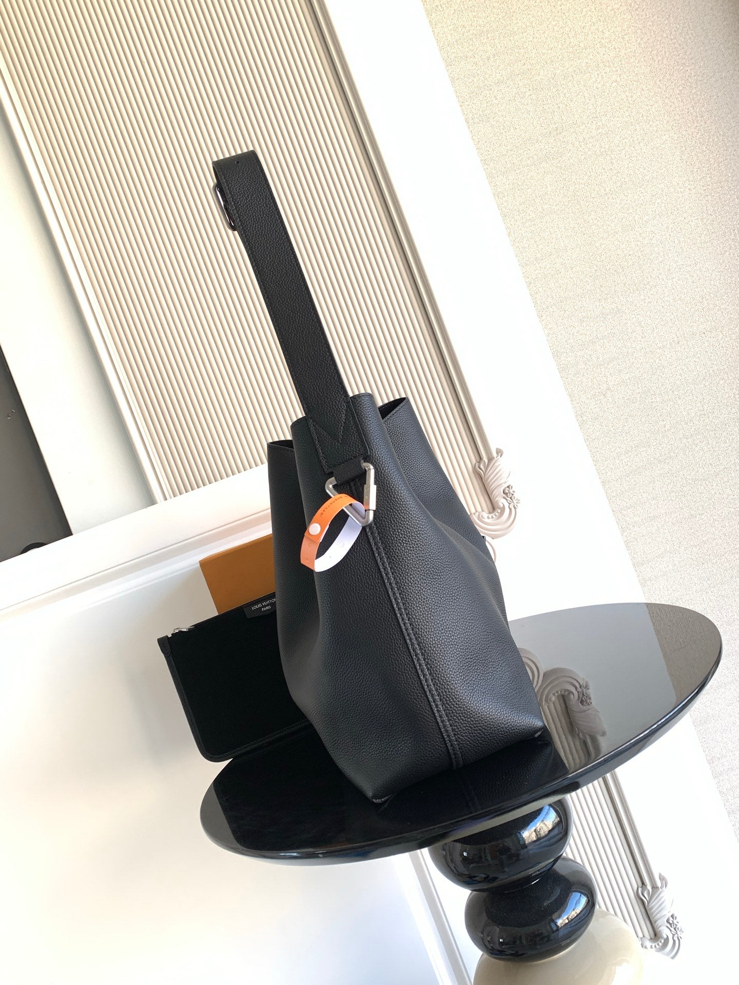 Black leather shoulder bag with adjustable strap and metal clasp
