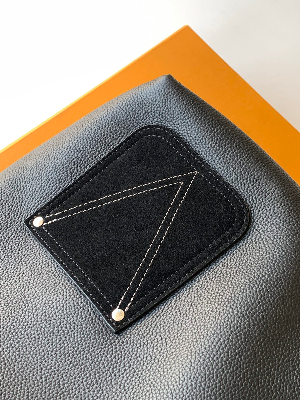 Black leather front patch pocket with contrast stitching and snap buttons