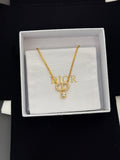 Gold-tone Dior pendant necklace with D charm and small crystal drop on white box