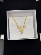 Gold-tone Dior pendant necklace with D charm and small crystal drop on white box