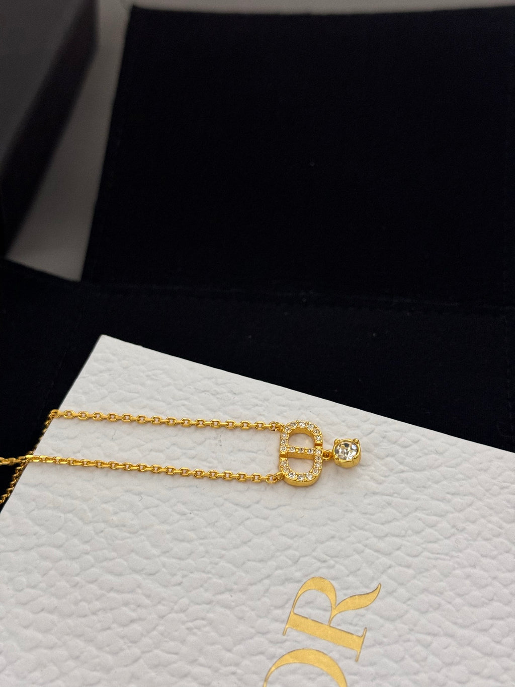 Gold-tone Dior pendant necklace with D charm and small stone detail on box