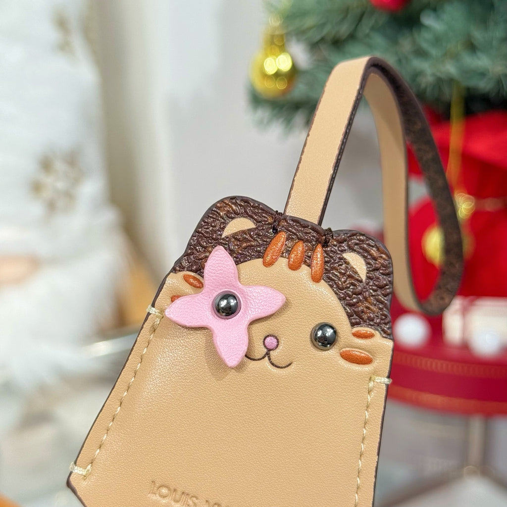 Close-up beige keychain accessory with cartoon animal face charm and strap loop