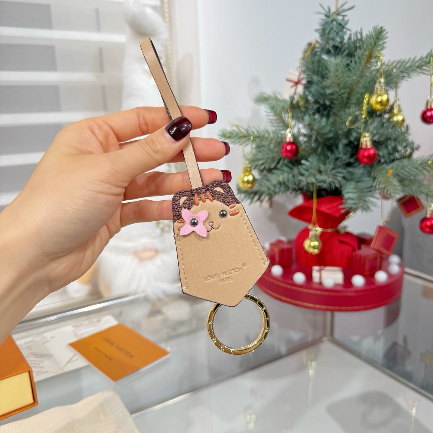 Beige keychain accessory with cartoon animal face charm and gold key ring