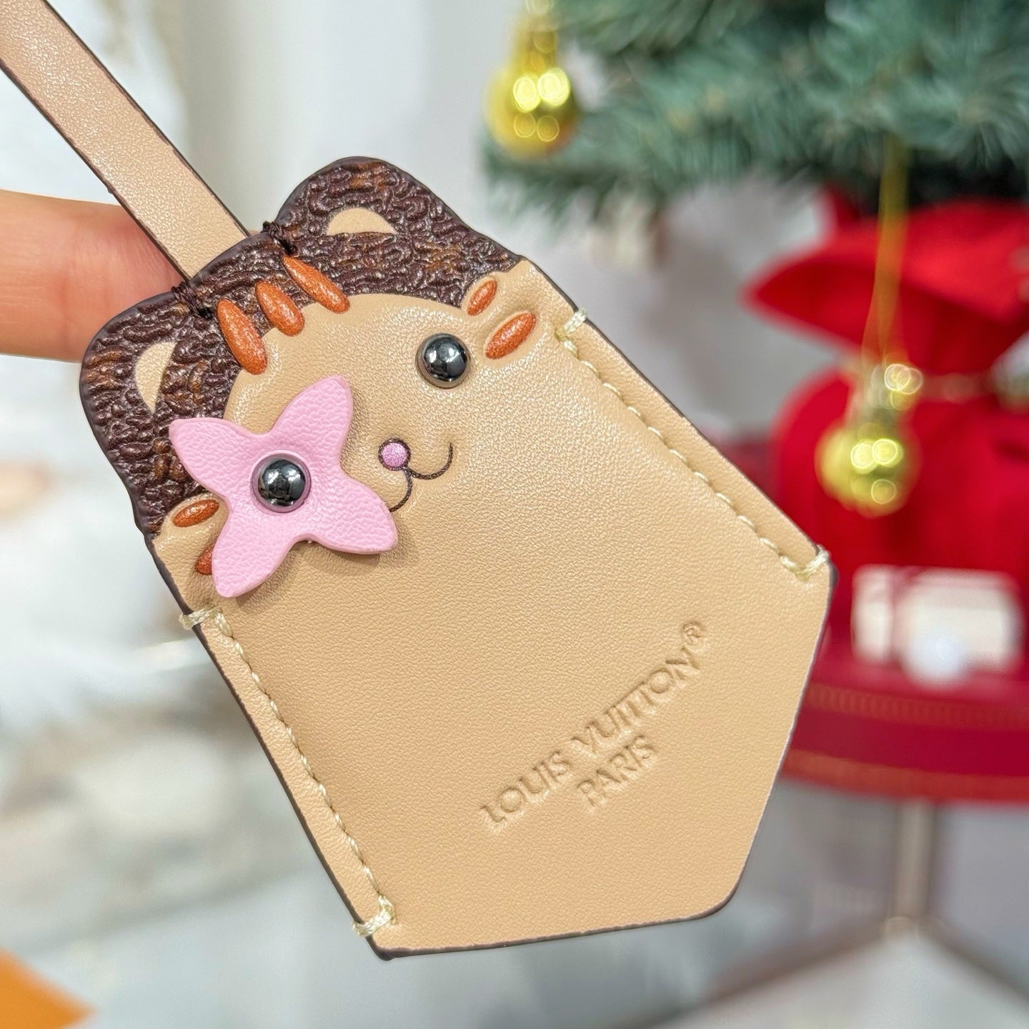 Beige leather keychain with cartoon animal face patch and stitched strap loop
