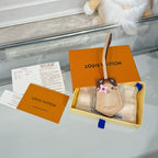 Beige keychain accessory with cartoon animal face charm on display