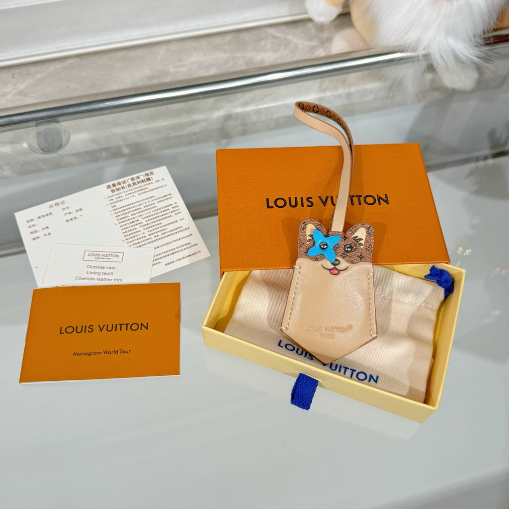 Louis Vuitton beige key pouch with blue cat face charm, shown on a box base