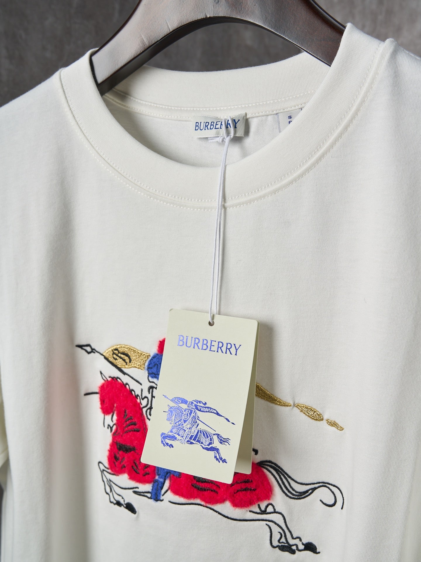 White T-shirt with hanging size label and multicolor polo graphic