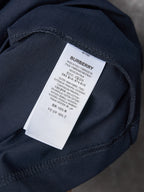 Navy T-shirt sleeve detail with white “BURBERRY” care label tag