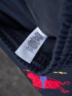 Navy pants with Burberry care label and embroidered horse graphic