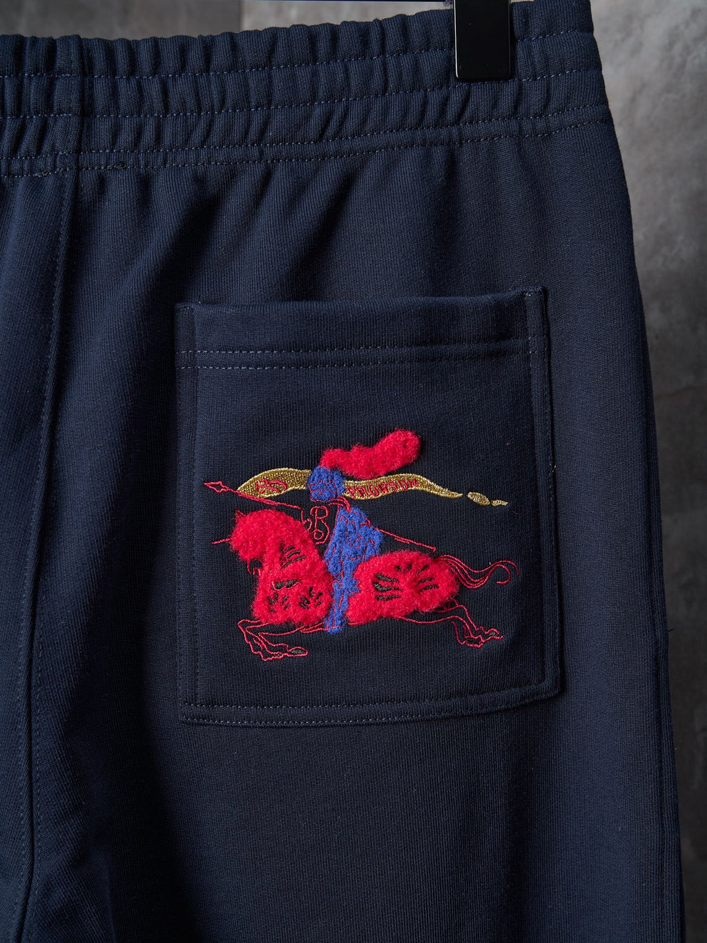 Navy pants with red and blue embroidered crest on front pocket