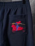 Navy pants with red and blue embroidered crest on front pocket