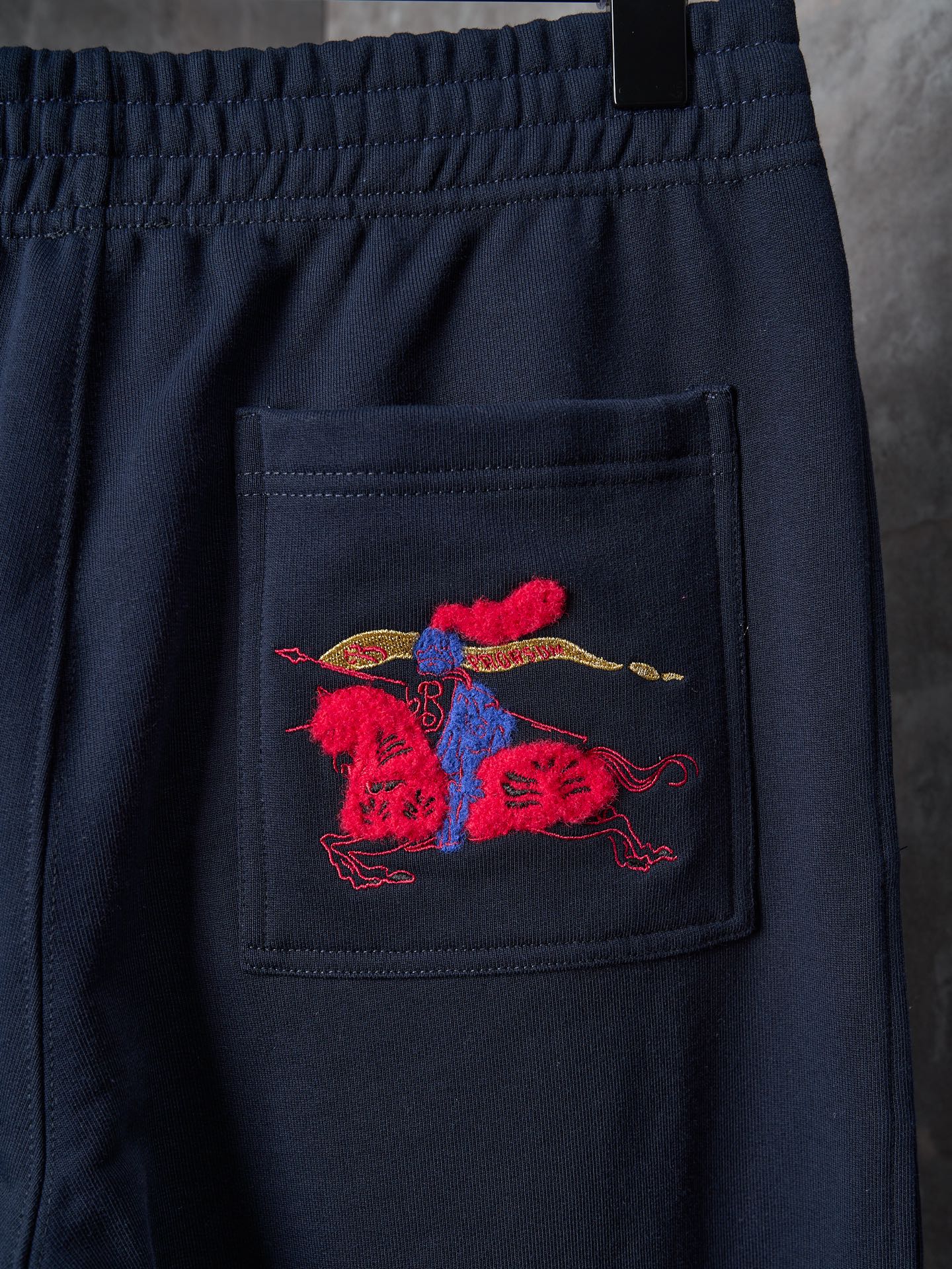 Navy pants with red and blue embroidered crest on front pocket