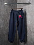 Navy jogger pants with a red horse logo on the front pocket