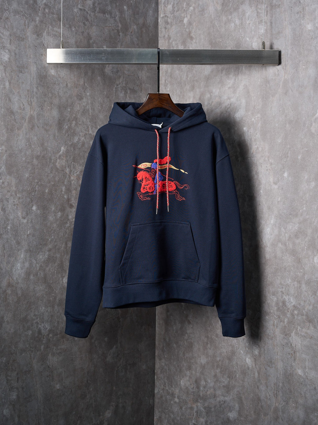 Navy pullover hoodie with embroidered red graphic and kangaroo pocket