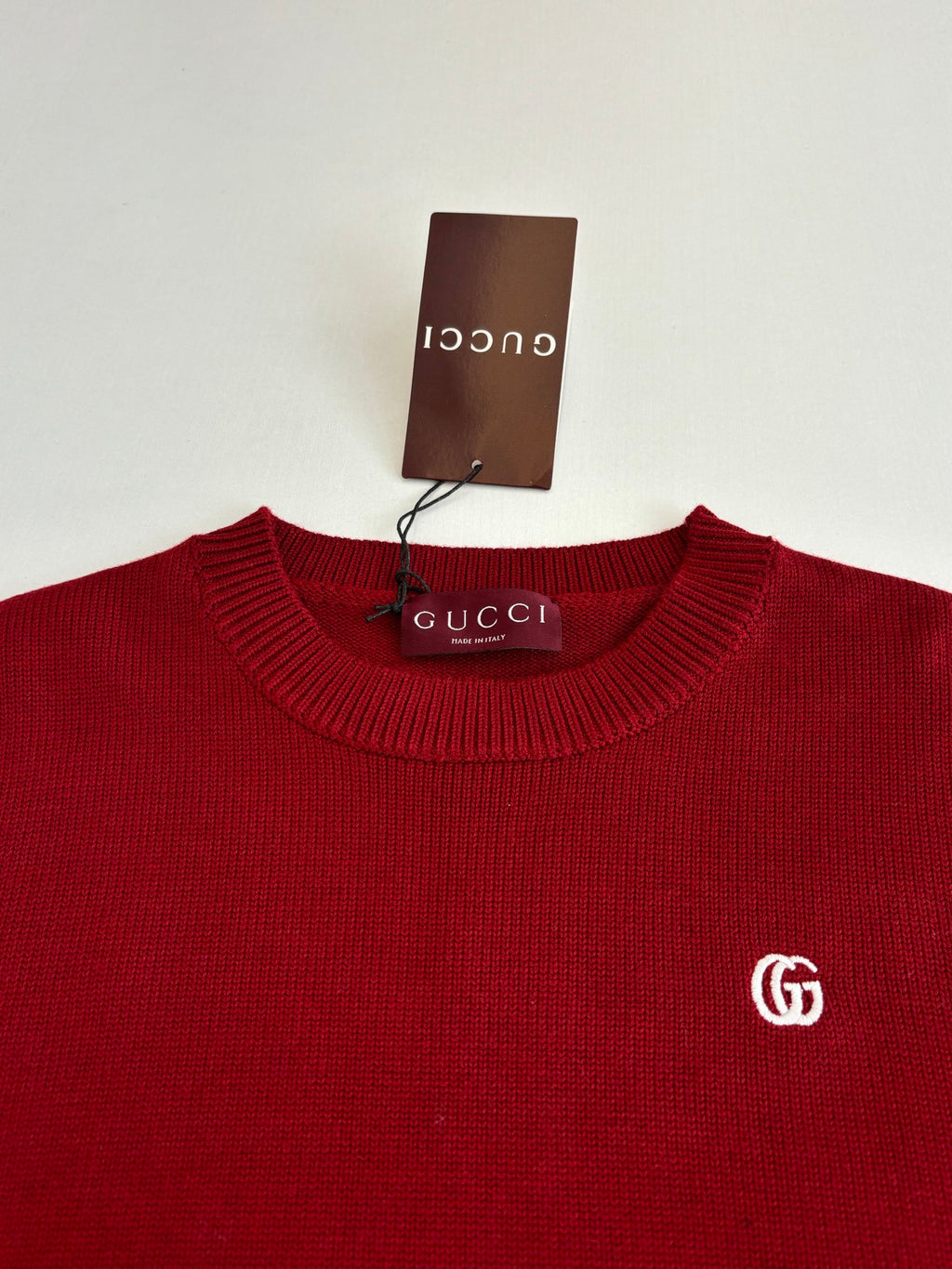 Red Gucci crewneck sweater close-up with GG logo on the chest
