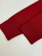 Red knit sweater sleeve cuff with ribbed knit texture