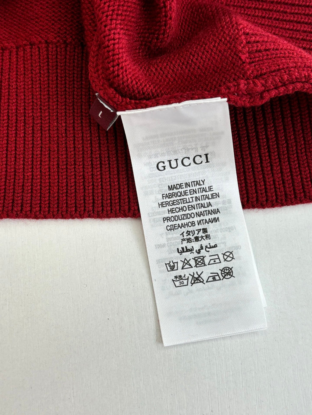 Red knit sweater with Gucci care label tag