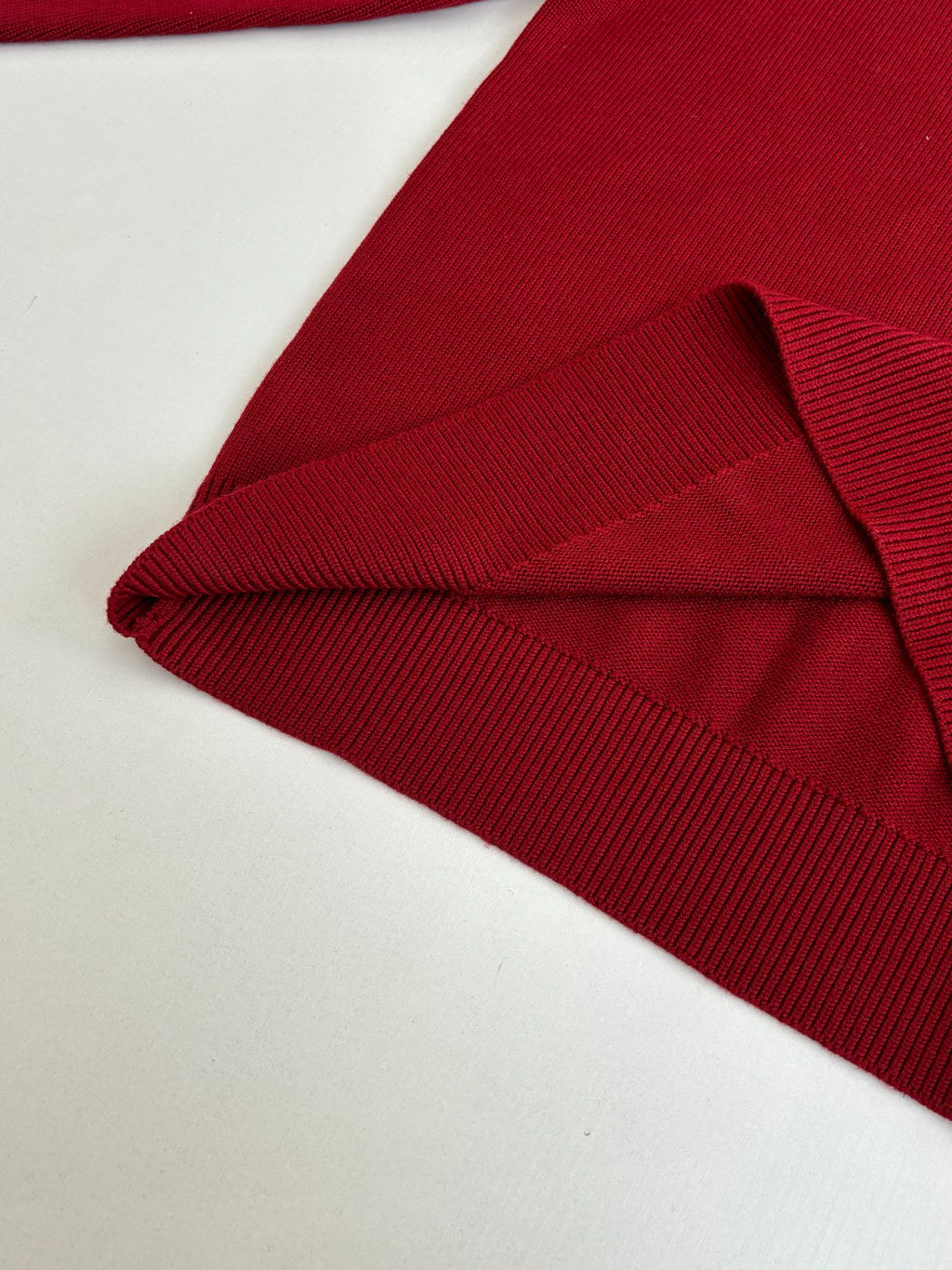 Folded red knit sweater with ribbed collar and cuff detail