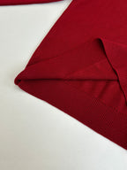 Folded red knit sweater with ribbed collar and cuff detail