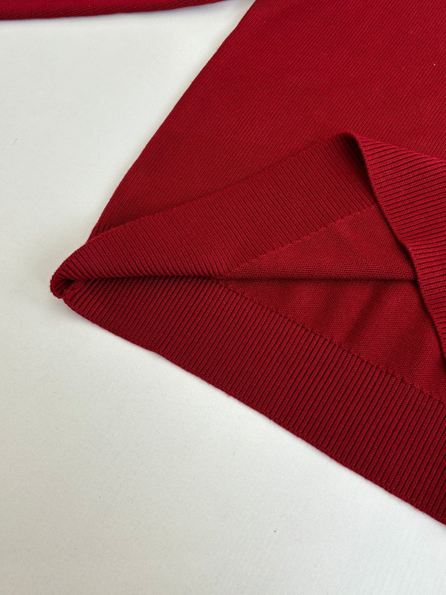 Folded red knit sweater with ribbed collar and cuff detail