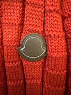 Red knit sweater sleeve with stitched leather-look patch detail