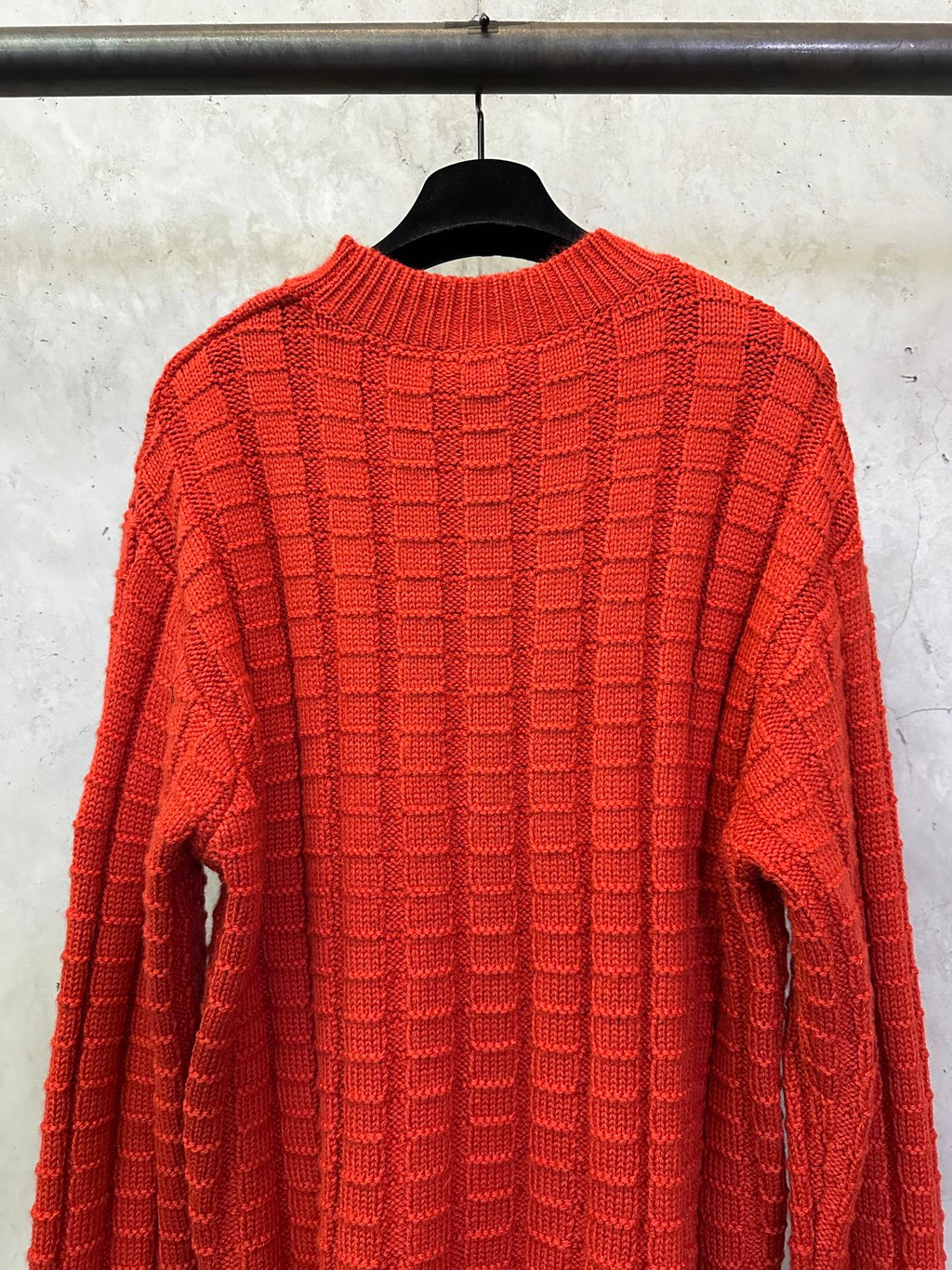 Red long-sleeve knit sweater front view with crew neck and grid texture