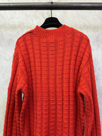 Red long-sleeve knit sweater front view with crew neck and grid texture