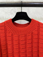 Red crew-neck knit sweater collar detail with ribbed edge and grid stitch