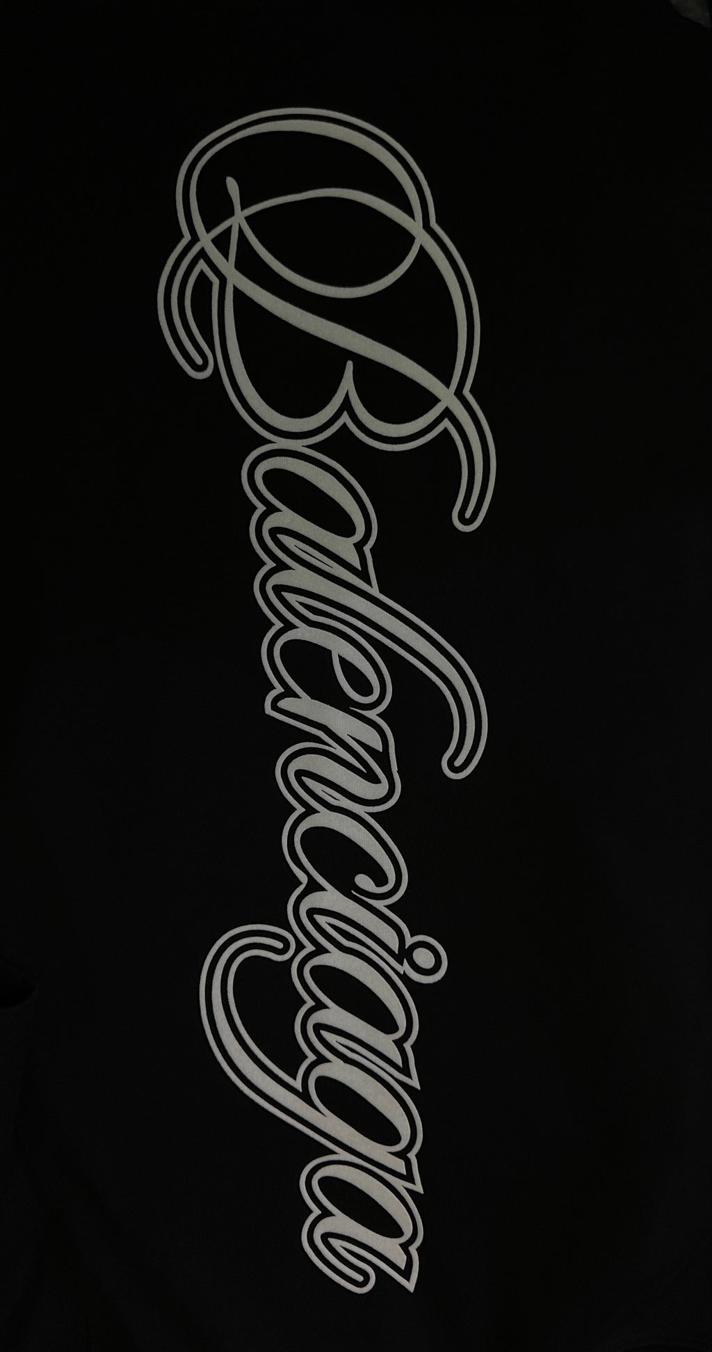 White script logo on black T-shirt fabric, close-up