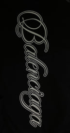 White script logo on black T-shirt fabric, close-up