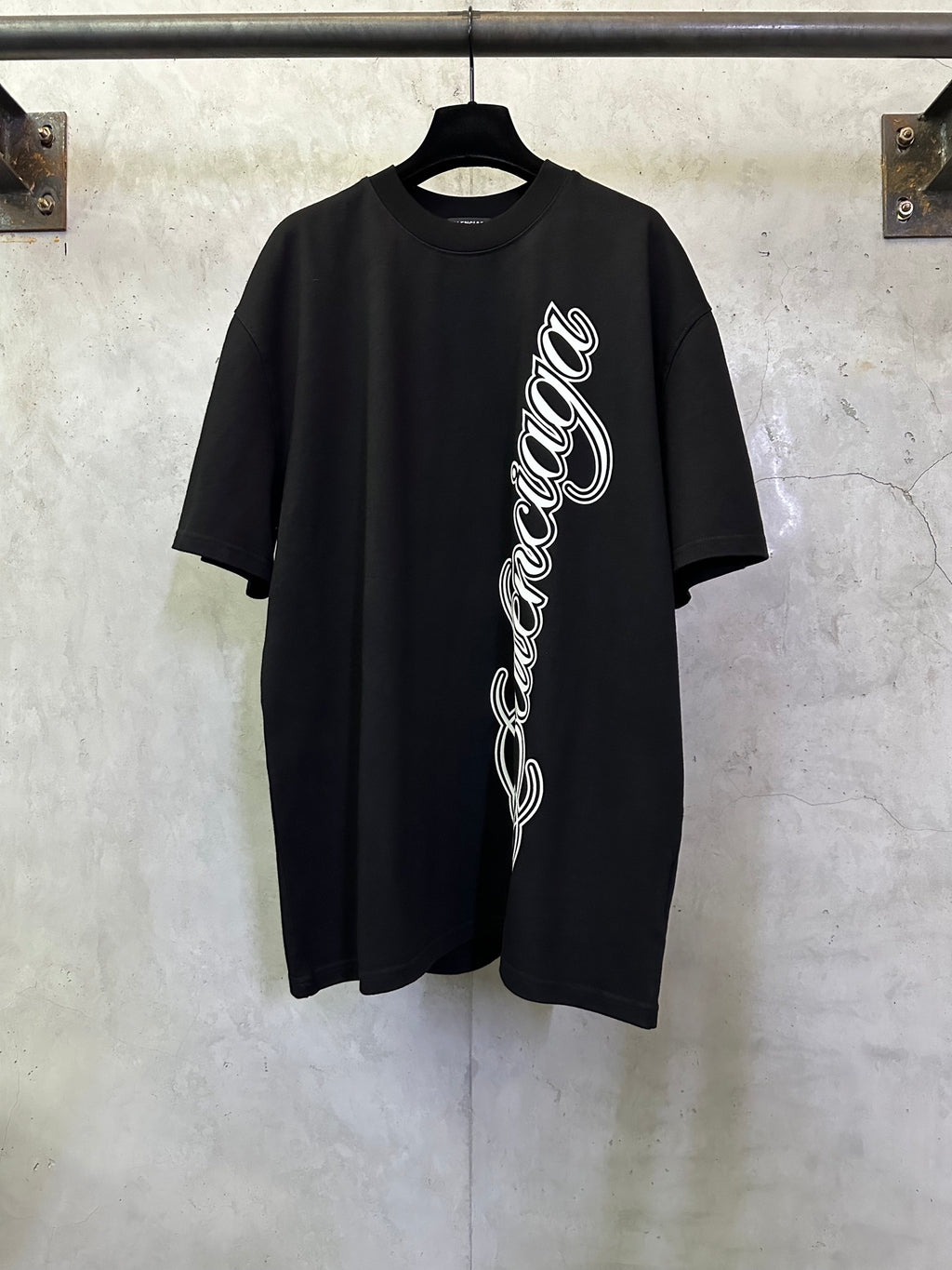 Black T-shirt with white script logo on the front, short sleeves, crew neck