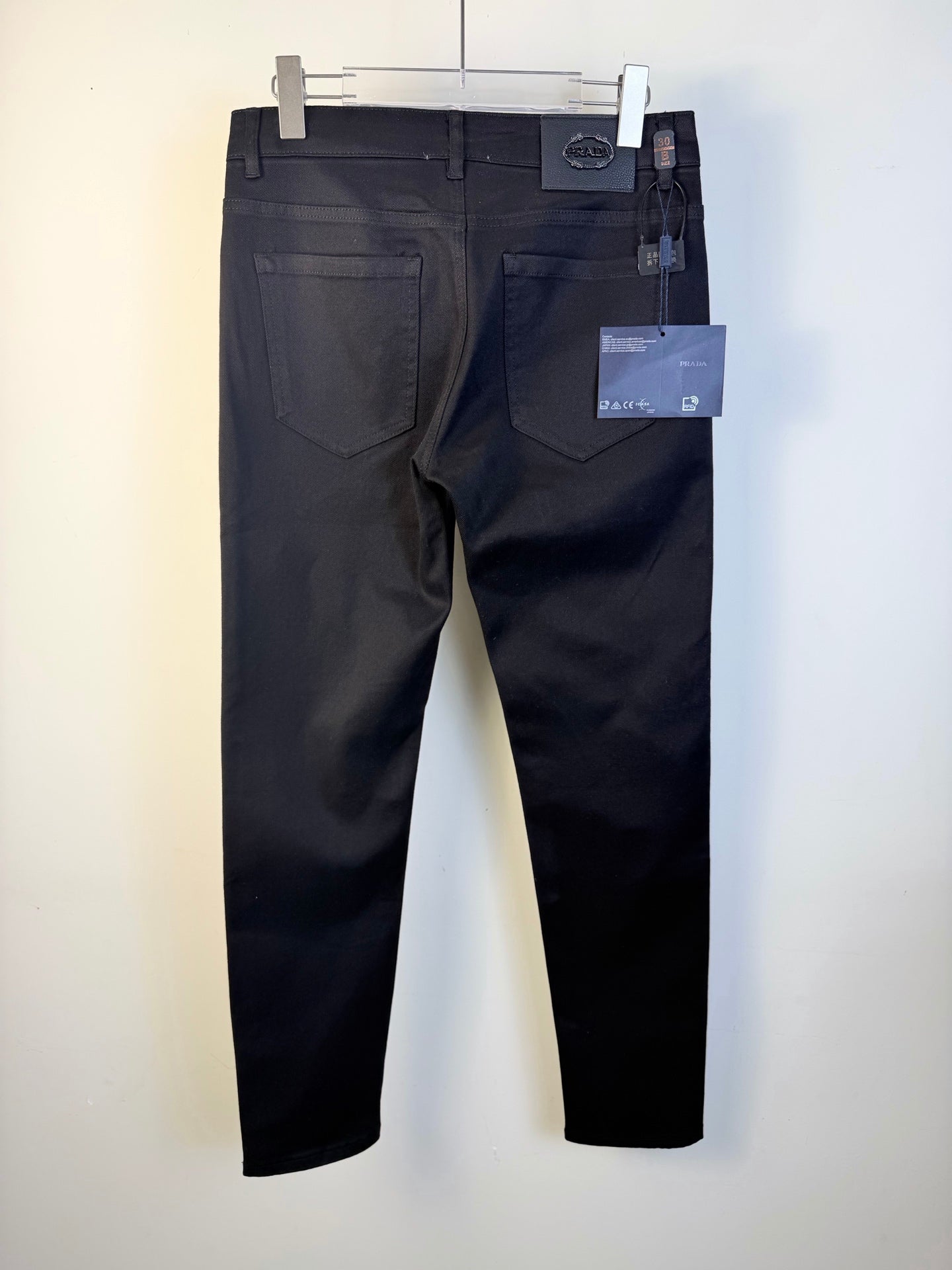 Prada dark blue pants on hanger with front pockets and hanging tags