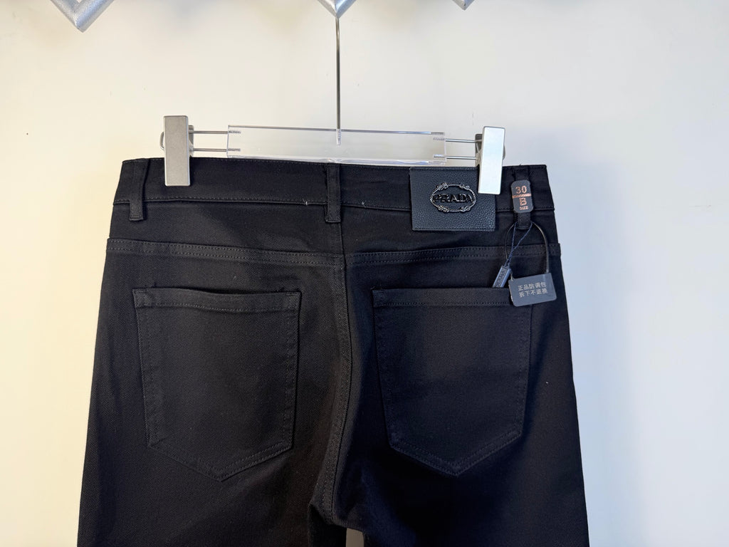 Prada pants front view with pockets and brand patch, dark blue, on hanger