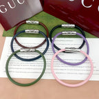 Gucci braided bracelets with logo bar clasp in dark green, navy, lavender, and pink