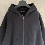 Dark zip-up hoodie close-up with hood and zipper at center front
