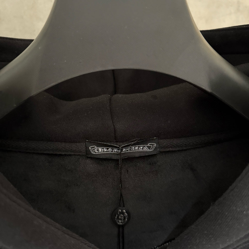 Dark hoodie inner neckline with sewn label and small black zipper pull
