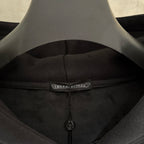 Dark hoodie inner neckline with sewn label and small black zipper pull
