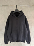 Dark zip-up hoodie with hood and front kangaroo pocket, hanging on a hanger