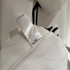 White hoodie with brand tag at collar and inner stitching